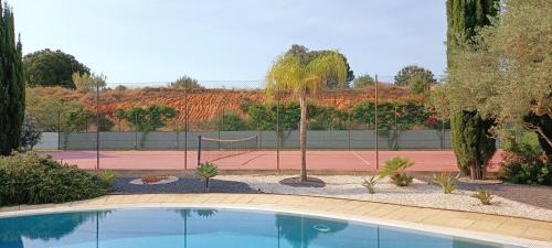 a swimming pool in front of a tennis court at RESIDENCE GOLF CLUB 415 in Quarteira