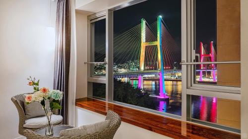 ein Fenster mit Blick auf die Brooklyn Bridge in der Unterkunft Yeosu Hotel Haven in Yeosu