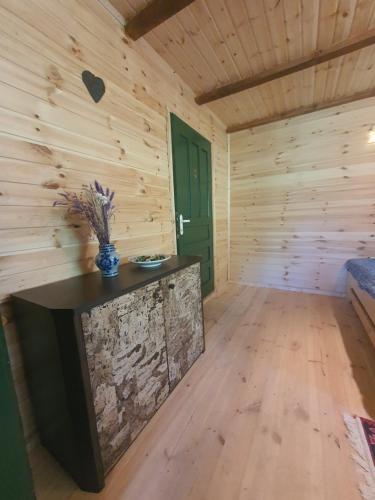 a large room with a wooden wall with a large stone fireplace at Almost Heaven - cabană cu vedere în Apuseni in Cîmpeni