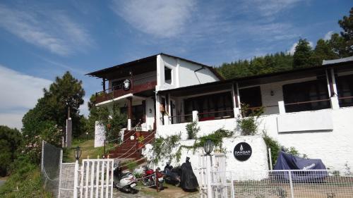 una casa bianca con una recinzione di fronte di Darbar - A Heritage Farmstay, Near New Tehri & Kanatal a Chamba