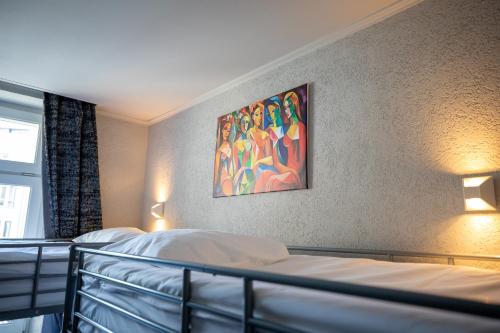 a bedroom with two beds and a painting on the wall at Hotel Bristol in Luxembourg