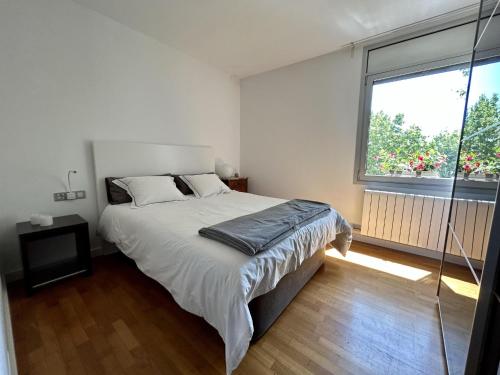 a bedroom with a large bed and a large window at Loft Bouquet Alella mar y montaña 25 min a BCN in Alella