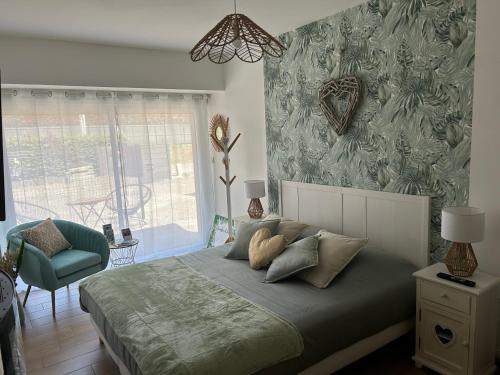 una camera con letto e sedia verde di La Carola a Bordeaux-Saint-Clair