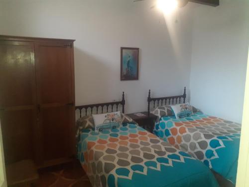 1 dormitorio con 2 camas individuales y armario en Casa Manuel, en Úbeda