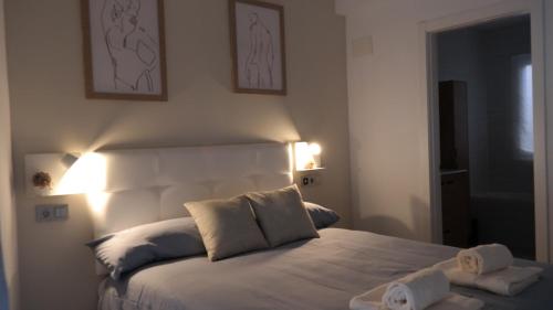 una camera da letto con un letto bianco e asciugamani di GEINTUR TOLEDO MARIBEL HERITAGE a Toledo