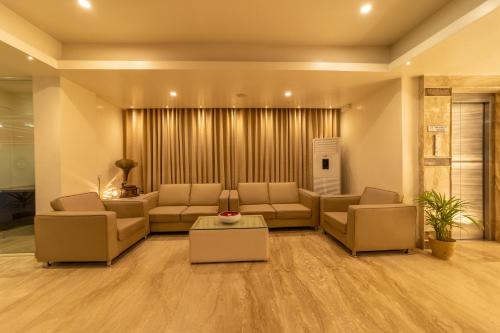 a living room with couches and a table at Tetrad Hotels - International Airport Road Hebbal in Bengaluru