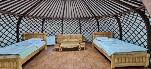 Zimmer mit 2 Betten und einem Tisch in einer Jurte in der Unterkunft Talbiun Lodge in Hujirt