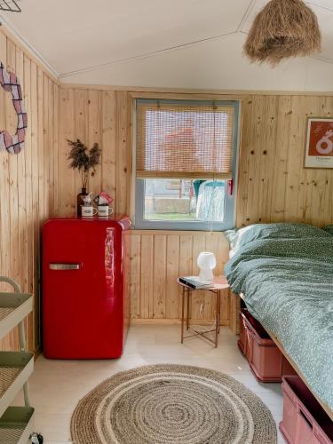 a room with a red refrigerator and a bed at Camping Rogowo in Mrzeżyno