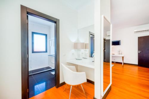 a room with a white table and a white chair at Villa Vacuna in Funchal