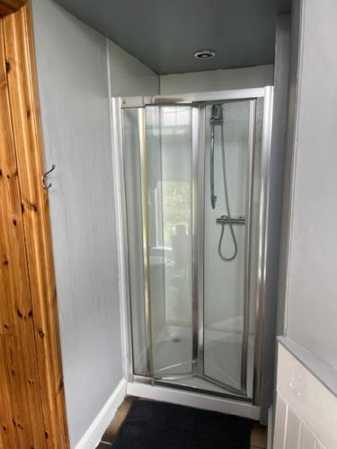 a walk in shower in a room next to a door at Duchally House in Nairn