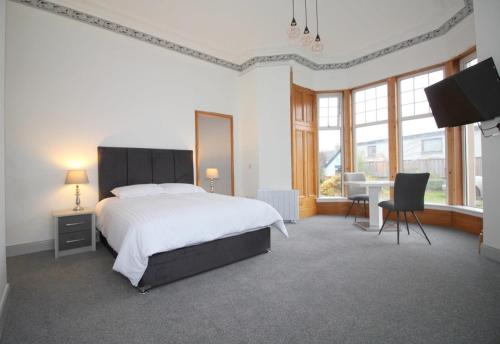 a bedroom with a large bed and a table and chairs at Duchally House in Nairn