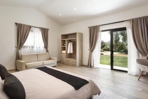 una camera con letto, divano e finestre di Uddastri Retreat a Arzachena