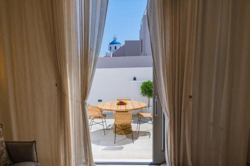 a view of a table and chairs from a window at La Madeleine Oia in Oia