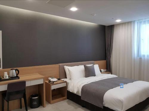 Habitación de hotel con cama y escritorio en Hotel Ciel Dongtan, en Hwaseong