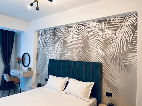 a bedroom with a bed with a green headboard at DAMAR Infinity Beach and Pool Mamaia- private parking in Mamaia Sat/Năvodari