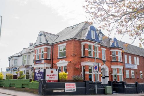 a red brick house with a for sale sign in front of it at Revado Hotel in Norwich