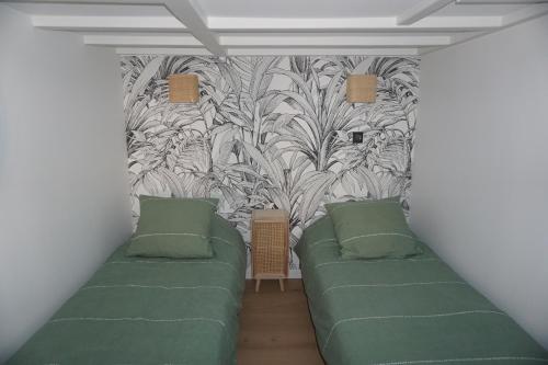 um quarto com 2 camas verdes e um mural de parede em Superbe appartement au bord de l'océan em Biarritz