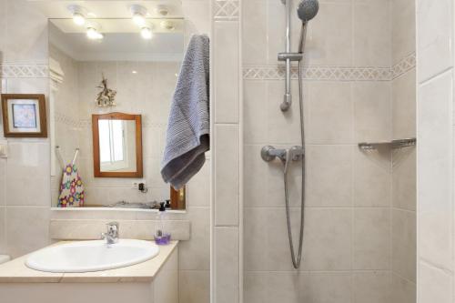 een badkamer met een douche en een wastafel bij Beachfront Bungalow in Torrox Costa