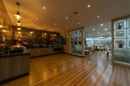 a restaurant with a bar with tables and chairs at Tetrad Hotels - International Airport Road Hebbal in Bengaluru