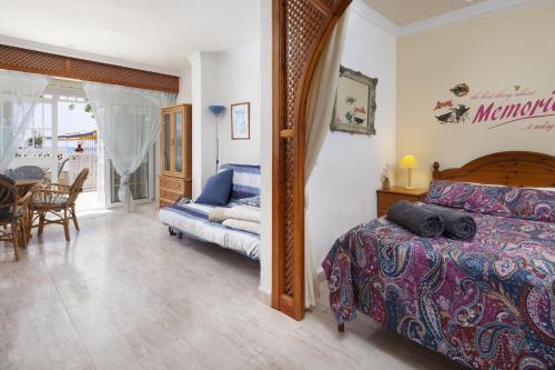 een slaapkamer met een bed en een eetkamer bij Beachfront Bungalow in Torrox Costa
