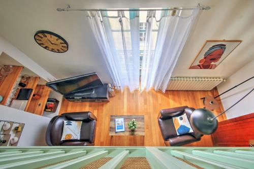 une chambre avec des chaises et une horloge sur le mur dans l'établissement Uncourtsejour - Nîmes la Rome française, à Nîmes