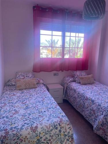 um quarto com 2 camas e uma janela em Vereda Golf - Apartamento em Roquetas de Mar