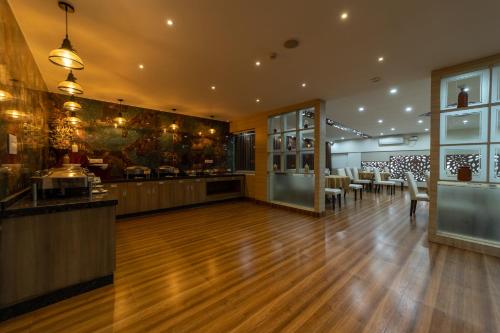 a restaurant with a bar with tables and chairs at Tetrad Hotels - International Airport Road Hebbal in Bengaluru