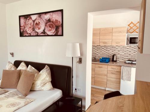 a living room with a couch and a kitchen at Attila Studio Apartments in Hajdúszoboszló