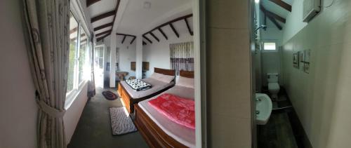 a bedroom with two beds in a room with a window at Acme Divine View in Nuwara Eliya