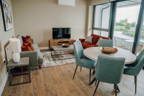 sala de estar con mesa, sillas y sofá en Shoreline Apartments en Galway