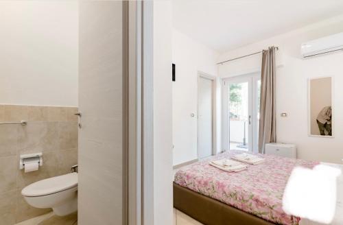 a bedroom with a bed and a bathroom with a toilet at Da Umby in Alghero