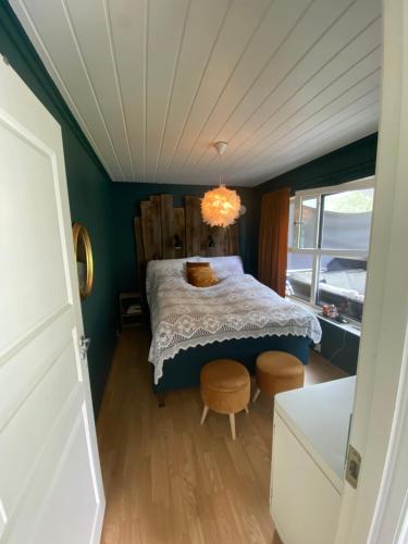 1 dormitorio con 1 cama y 2 sillas en Stryn Sentrum 3 soverom, en Stryn
