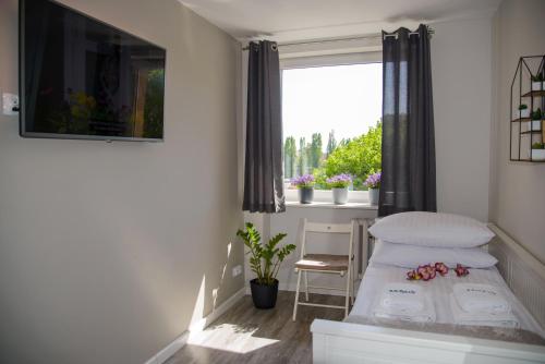 ein kleines Schlafzimmer mit einem Bett und einem Fenster in der Unterkunft Maya's Flats & Resorts - Gdańsk Szopy in Danzig