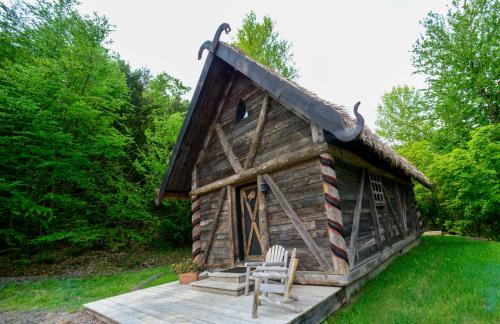 a log cabin with two chairs in front of it at Vikings Villages Resort in Guilford