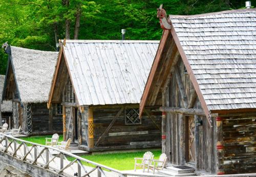 an old log cabin with chairs and a roof at Vikings Villages Resort in Guilford
