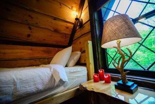 a bedroom with a bed and a lamp and a window at Vikings Villages Resort in Guilford