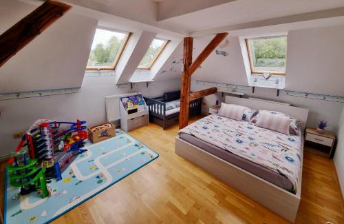 a small bedroom with a bed and a play area at Penzion ORION in Petrovice