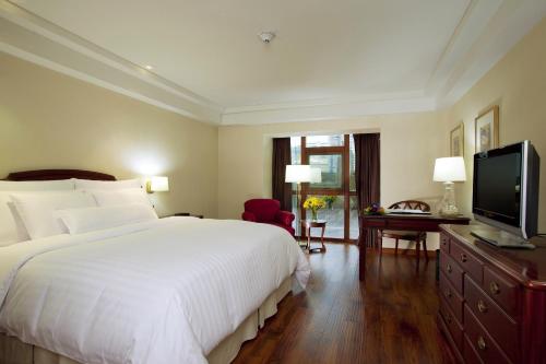 a bedroom with a large white bed and a television at Swissotel Lima in Lima