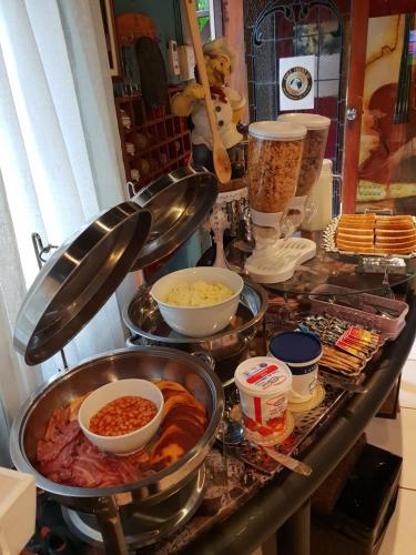 Un buffet con tazones de comida en un mostrador. en Eagle Forest inn, en Durban