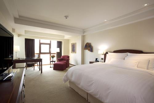 a hotel room with a large bed and a desk at Swissotel Lima in Lima