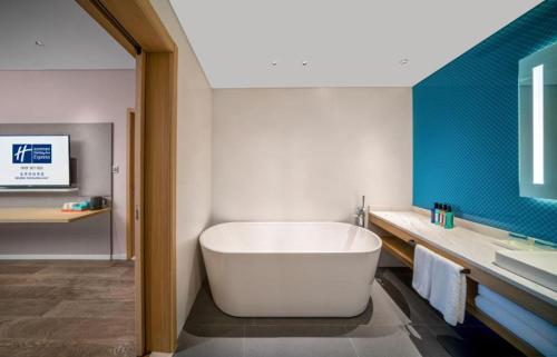 uma casa de banho com uma banheira branca e um lavatório. em 北京亦庄通明湖智选假日酒店 em Pequim