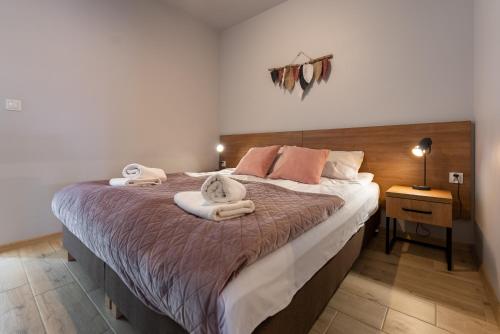 una camera da letto con un grande letto con asciugamani di Apartament Zielony Jodłowa - z prywatną sauną! by Dream Apart a Szczyrk