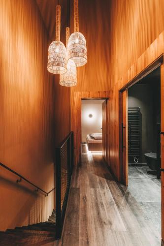 a hallway with two chandeliers and wooden walls at Hüttendorf Schlögelberger in Sankt Margarethen im Lungau