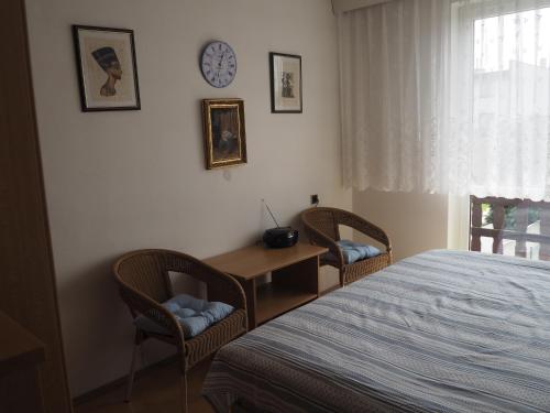 a bedroom with a bed and two chairs and a desk at Penzion Frederika in Mariánské Lázně
