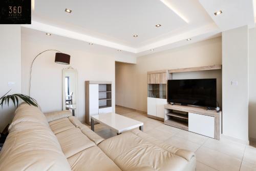 uma sala de estar com um sofá grande e uma televisão de ecrã plano em Beautiful, spacious 3BR home with private Balcony with 360 Estates em St. Julian's