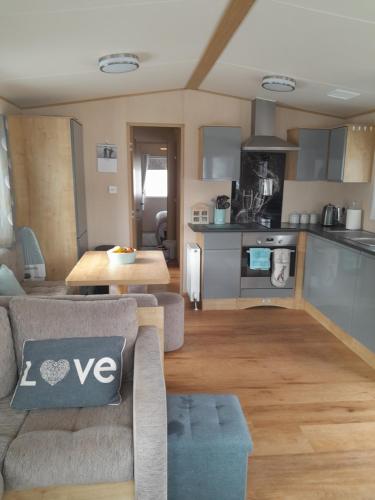 ein Wohnzimmer mit einem Sofa und einer Küche in der Unterkunft Happy place no4 in Ringwood