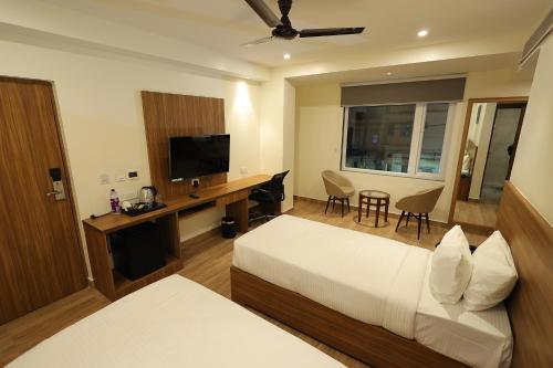 a hotel room with a bed and a flat screen tv at Hotel Sharda Residency in Patna