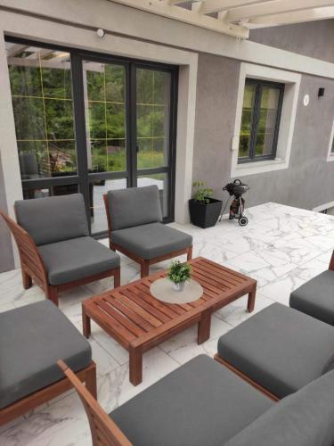 a patio with chairs and a wooden table and chairs at Guesthouse Müller in Ilindentsi