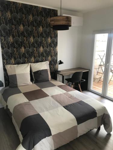 - une chambre avec un lit noir et blanc et un bureau dans l'établissement Joli appartement T3 rénové serviettes non incluses, à Sète