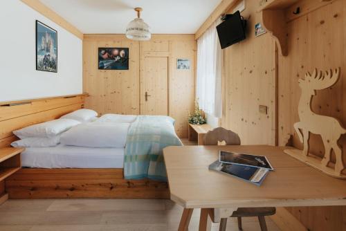 Locanda Montana في سان فيتو دي كادوري: غرفة نوم بسرير وطاولة